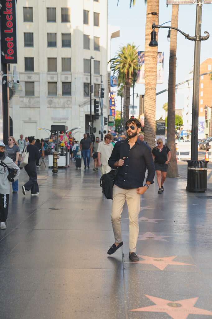 Young solo professional traveler posing confidently on the Hollywood Walk of Fame in Los Angeles, California, captured by Hollywood BL Photo.